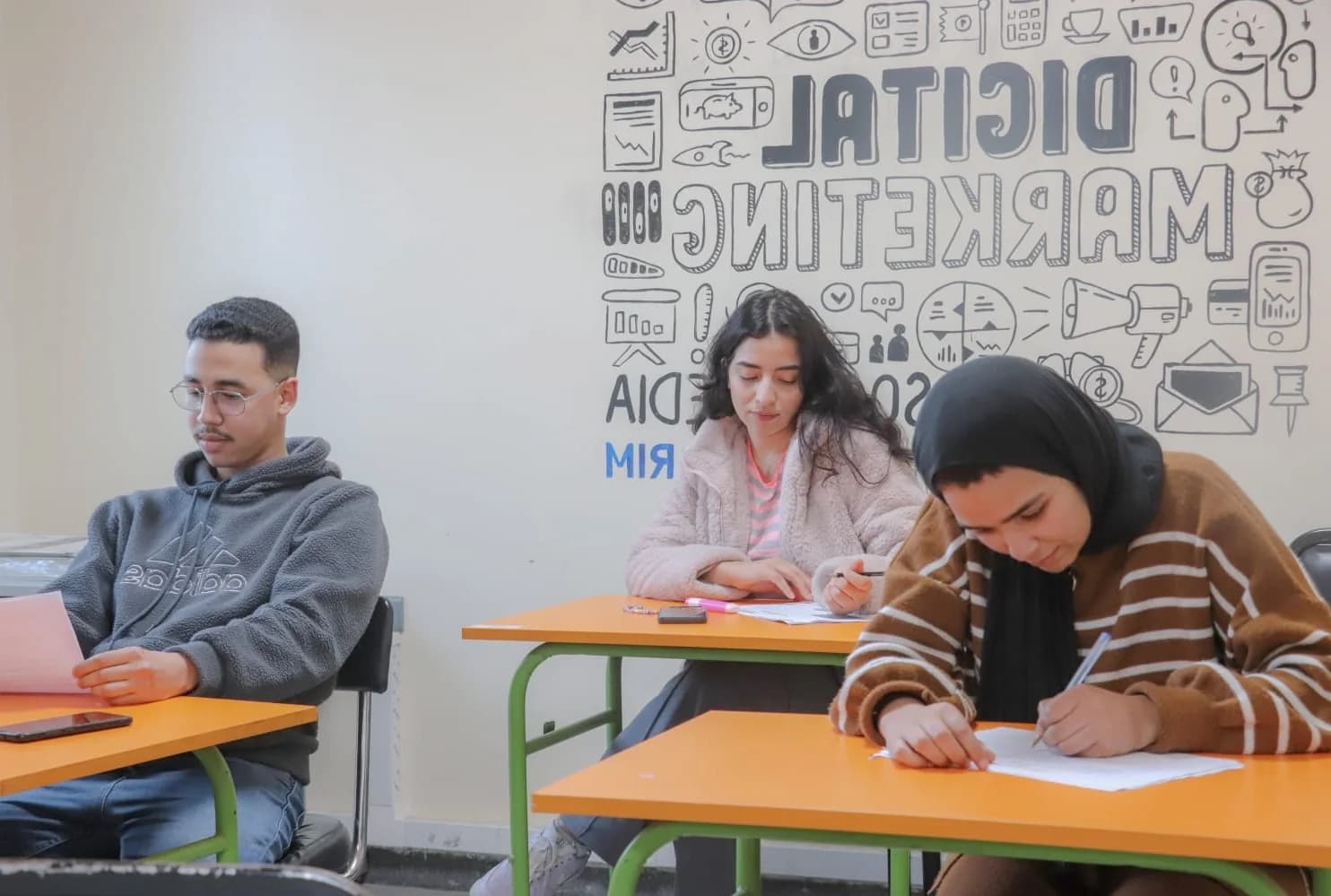 Étudiants lisant et travaillant autour d’une table dans un espace de ressources